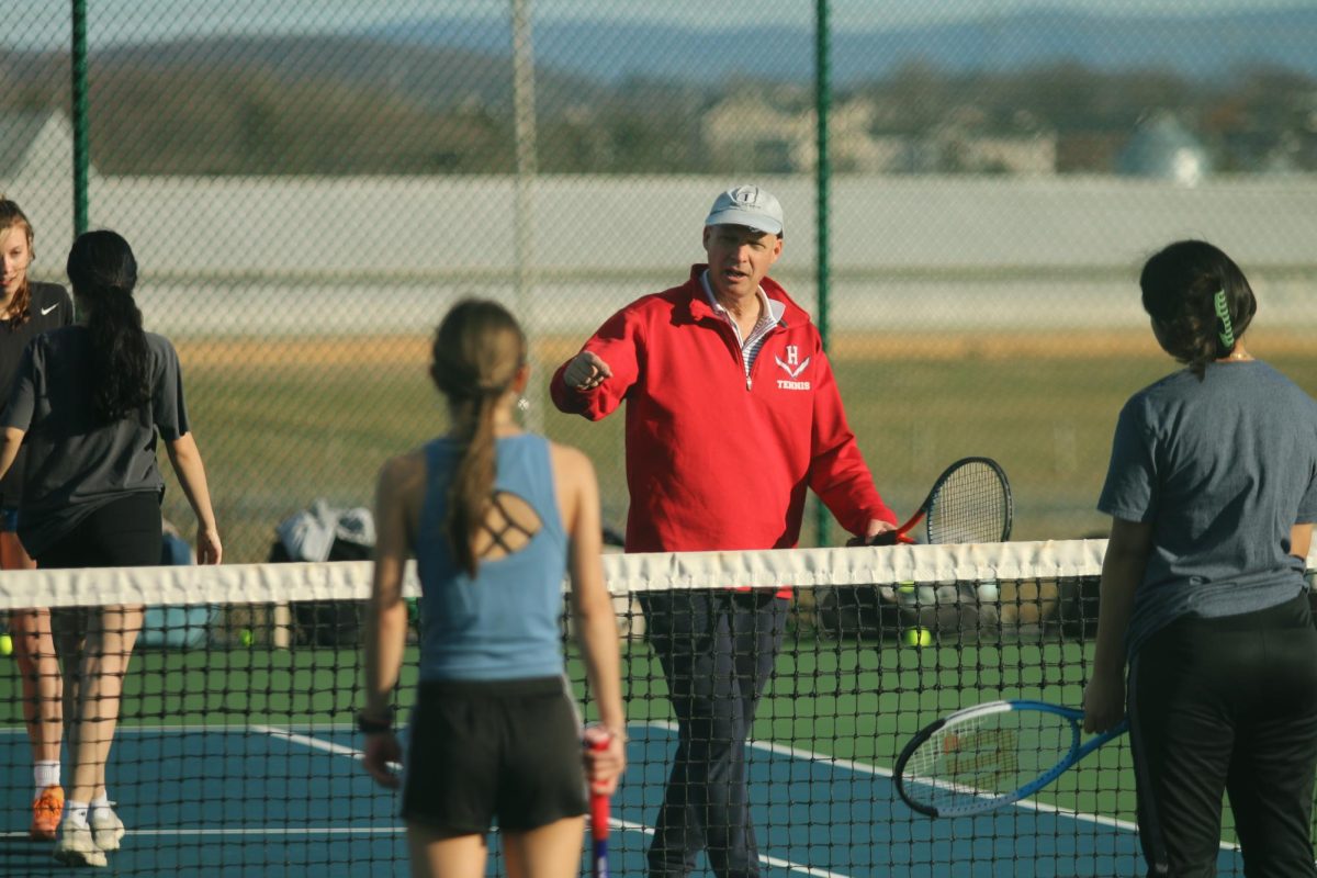 Tennis coach tells players what to do during the girls tennis tryouts this week