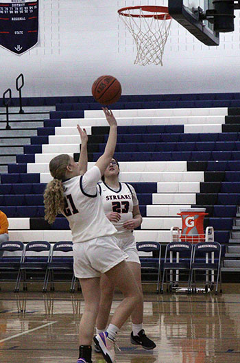 Leah Crawford and Jana Hayajneh go for the ball during practice as it falls out of the net.