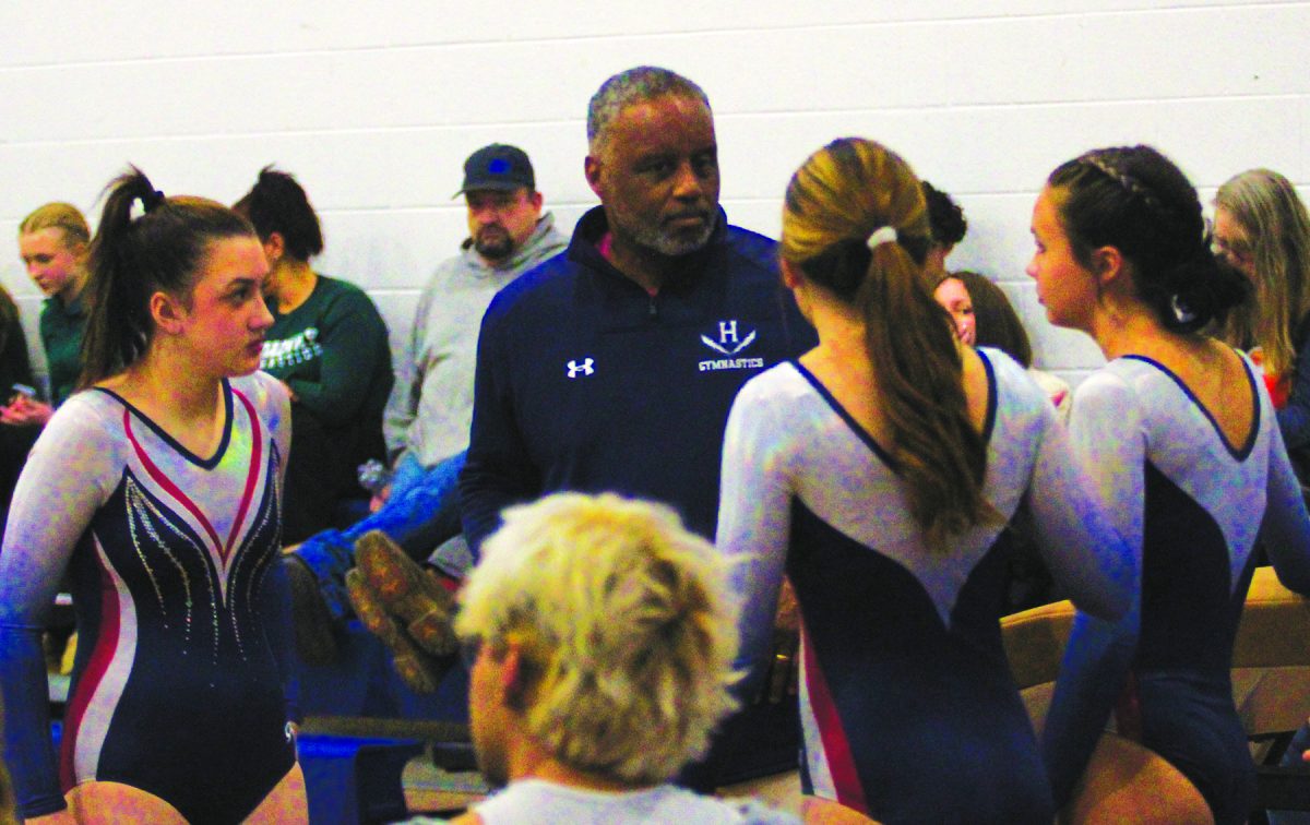 Gymnastics coach Michael King talks to one of his gymnasts prior to an event.