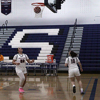 Kayli Alvarado and Ah-Ghia Jones make sure the ball gets through the net so they can catch it.