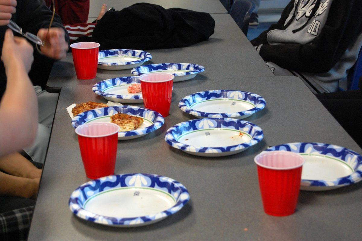 Students sit down to eat pizza before activates start.