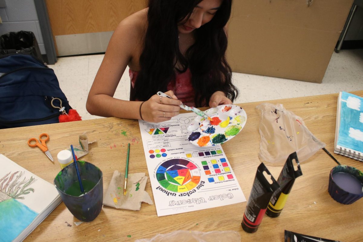 Student making art in art class.