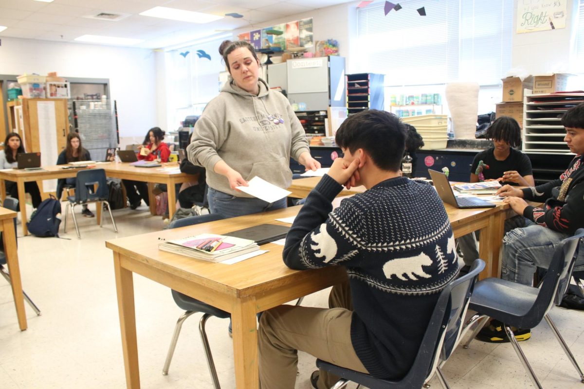 Art teacher showing student how to do something