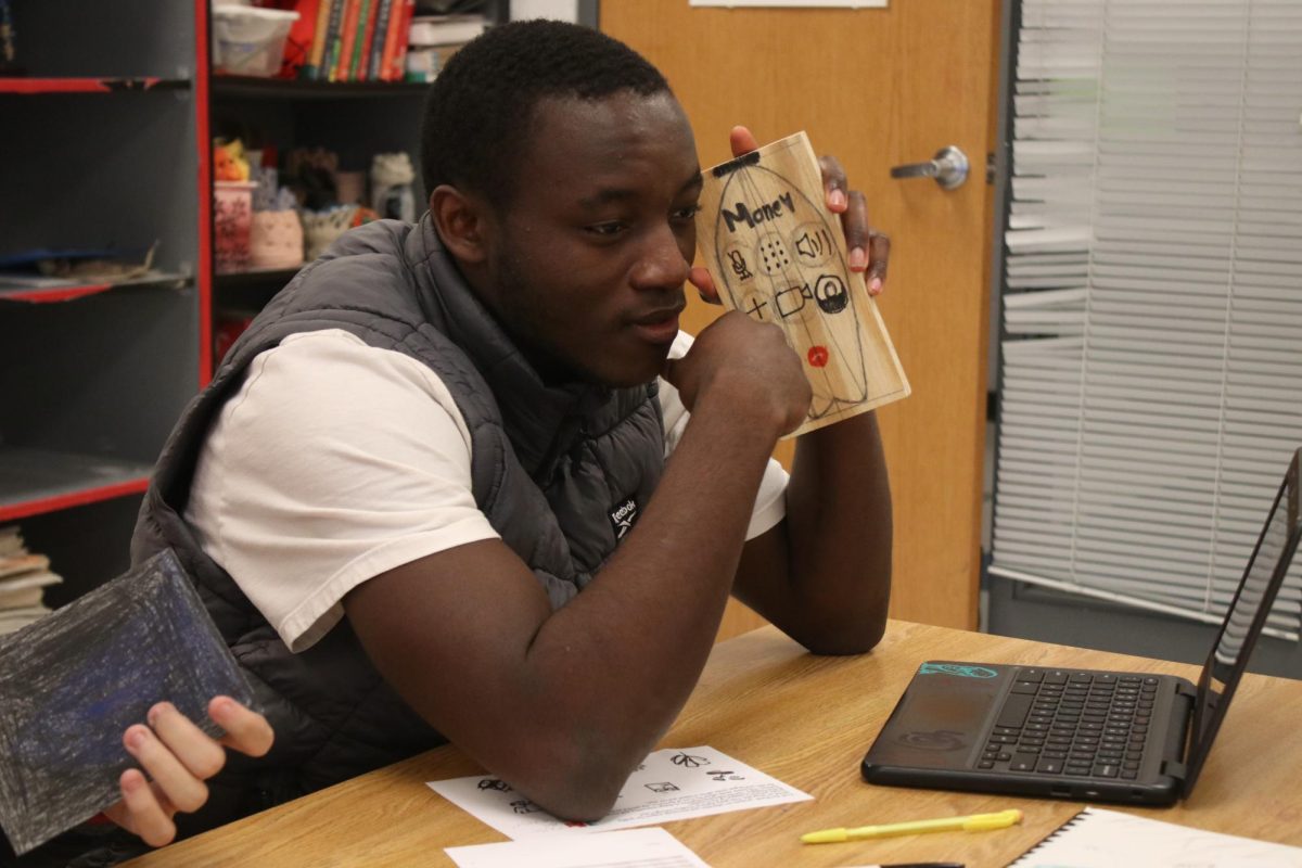 Student showing off his art piece