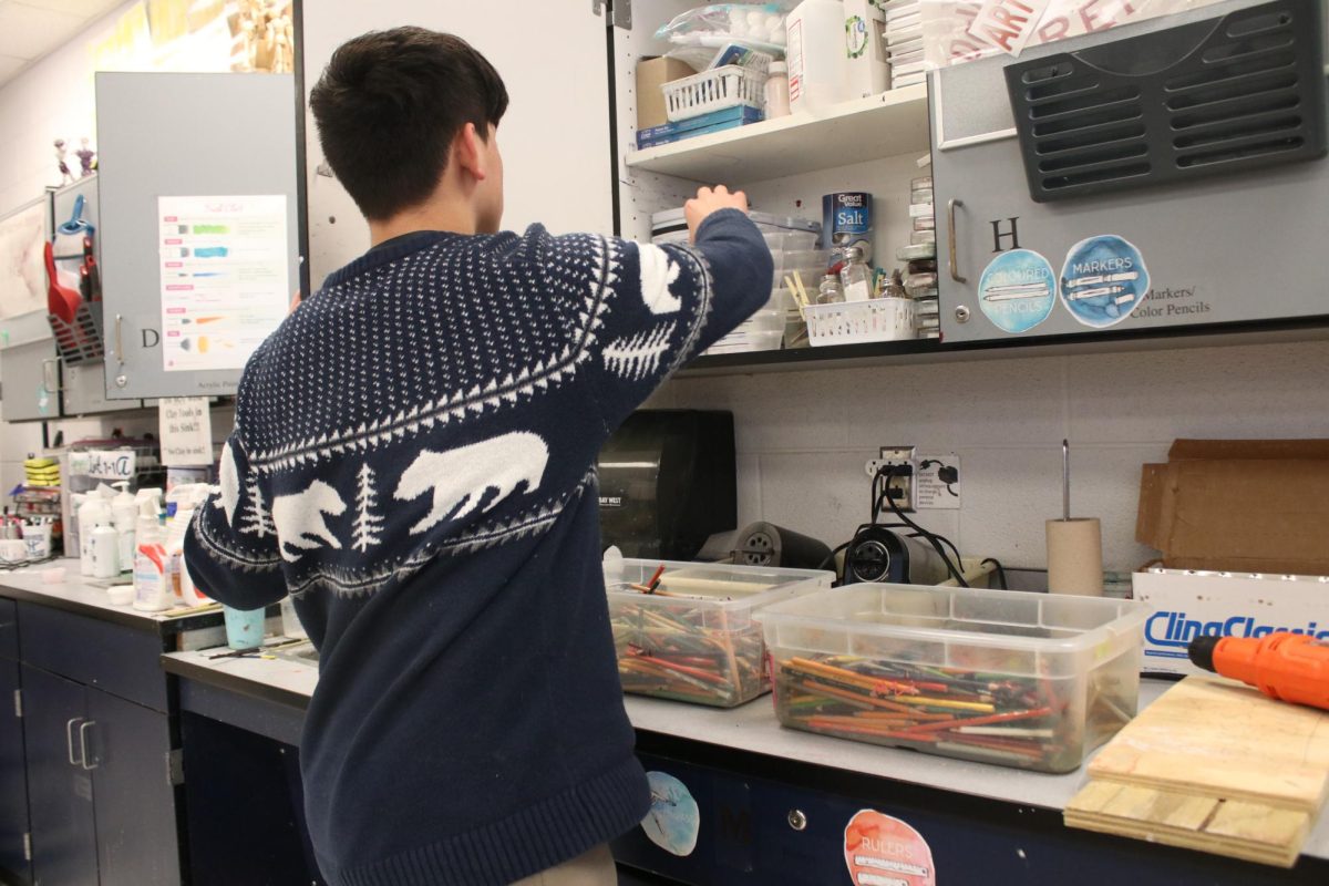 Freshman Victor Casula Sorto washing his hands after painting 
