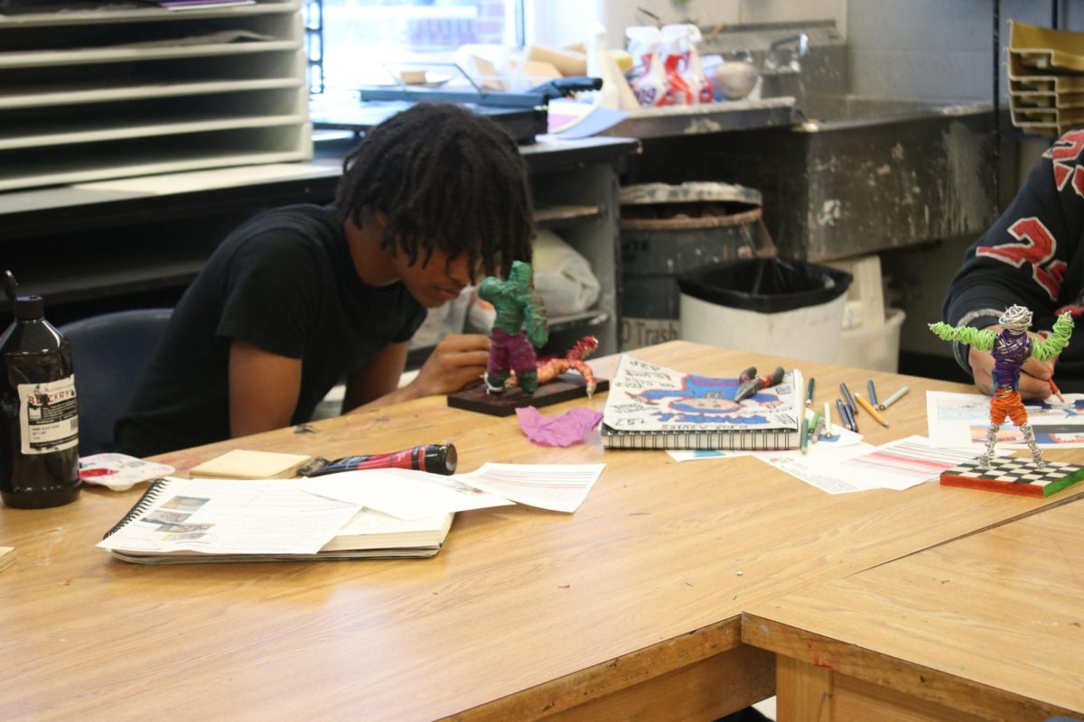 Freshman Mordecai Embaye sculpting in Art 1