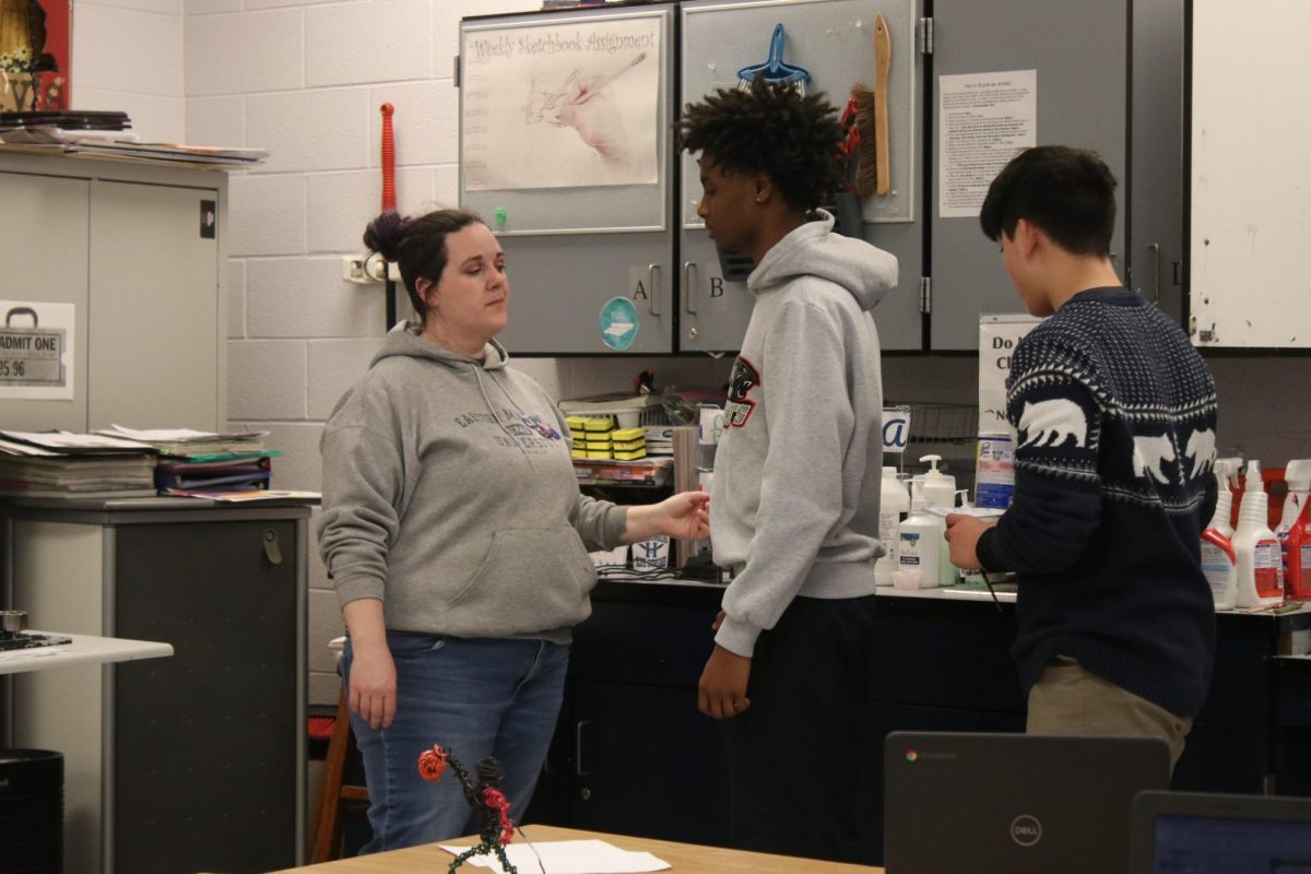 Teacher talking to students about their grades.