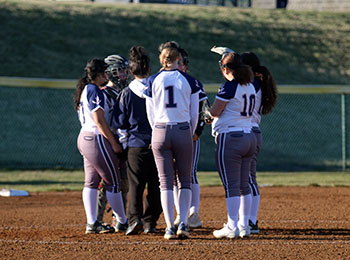 The JV softball team huddling on the mound.