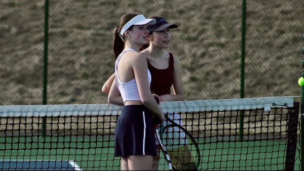 Seniors Macy Waid and Sequoia Hall talk during tennis practice.