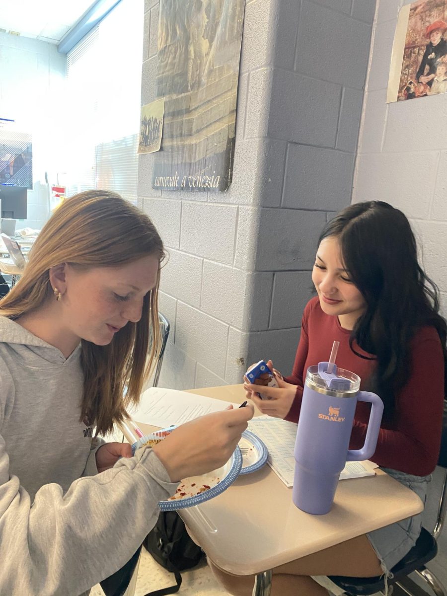 Sophomores Avery Holt and Leah Yoder talk and eat cheesecake another student brought in.