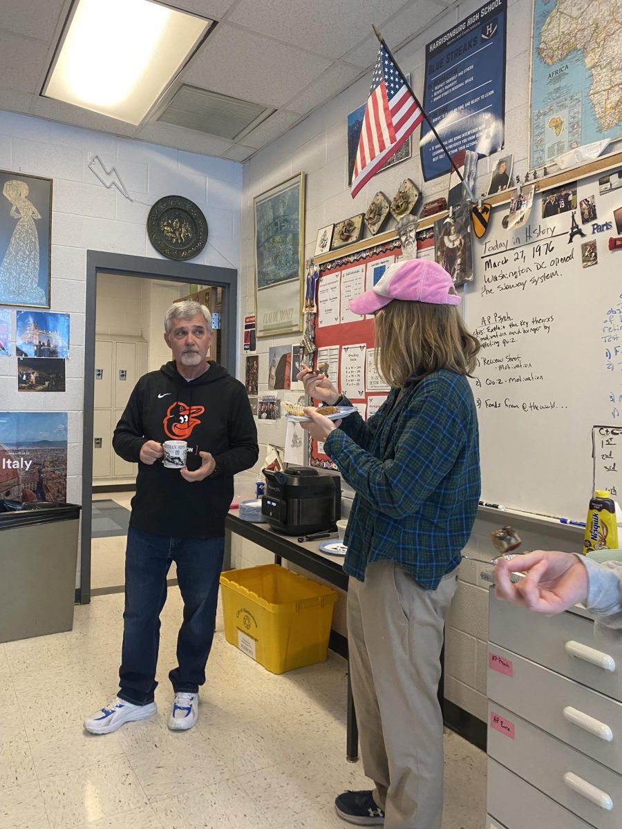 Psychology teacher Marc Healy and a student talk while eating food brought in.