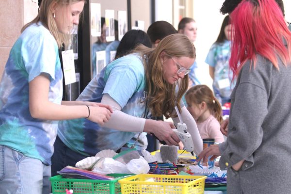 Junior Jane Shirkey helps people using hot glue.