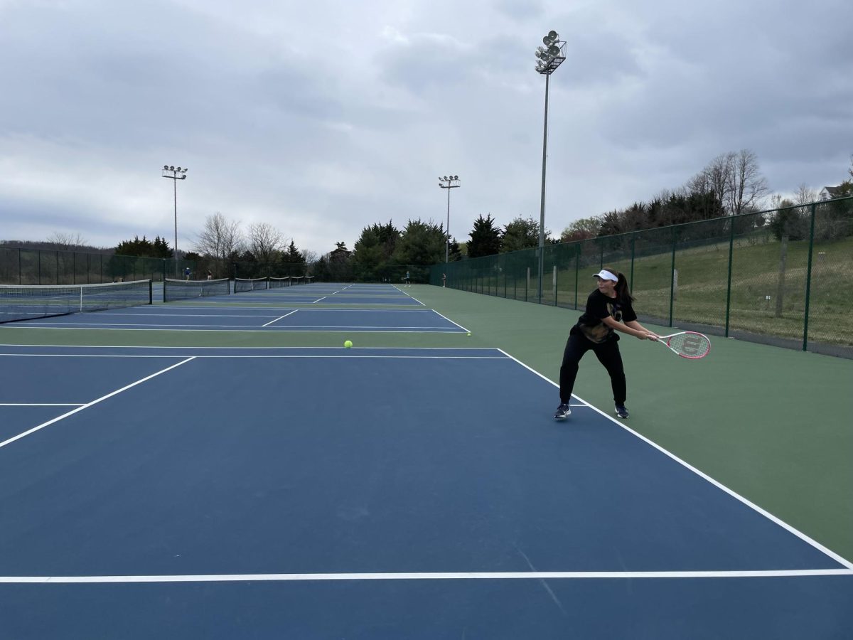 Junior Milana Utekeyeua practices hitting with her backhand swing. 
