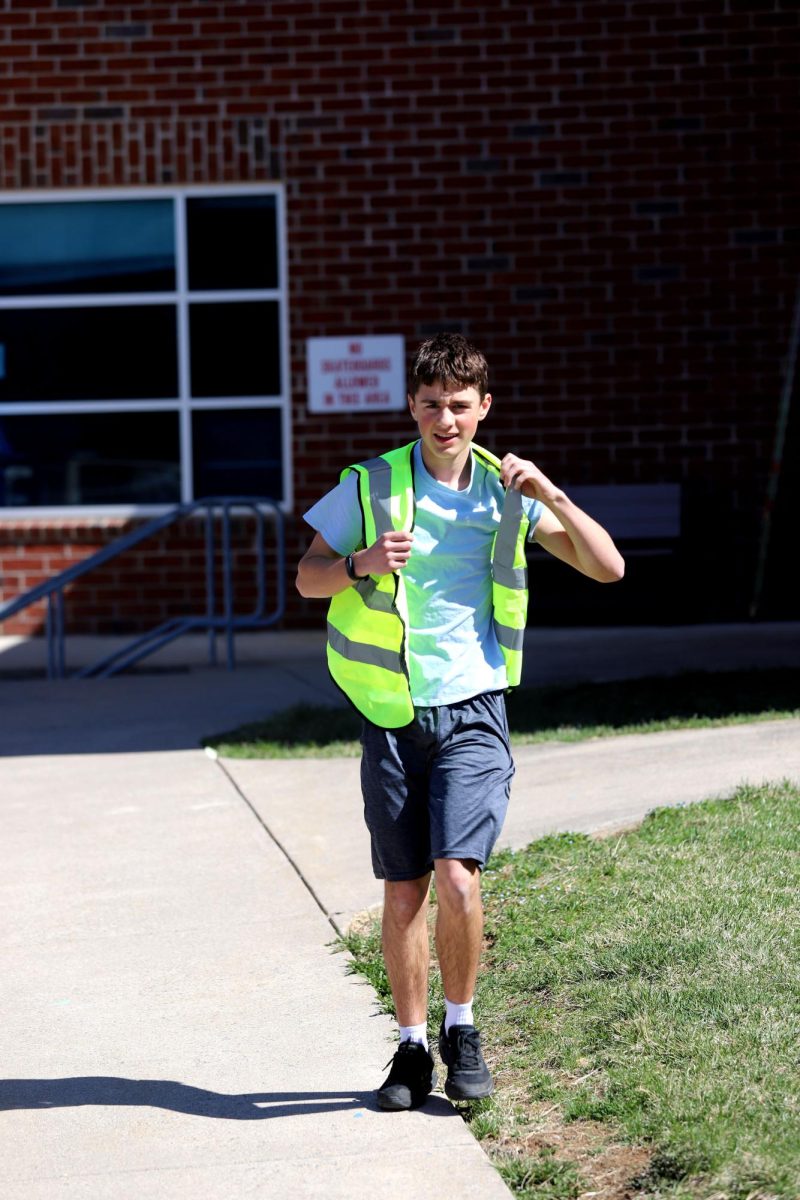 Sophomore Josiah Nafziger puts on his pit crew vest and walks out to the car.
