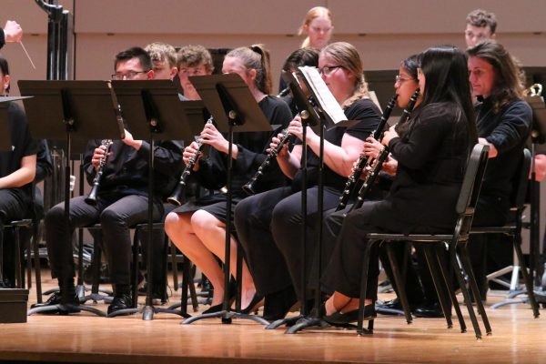 Students in visiting band play clarinet.