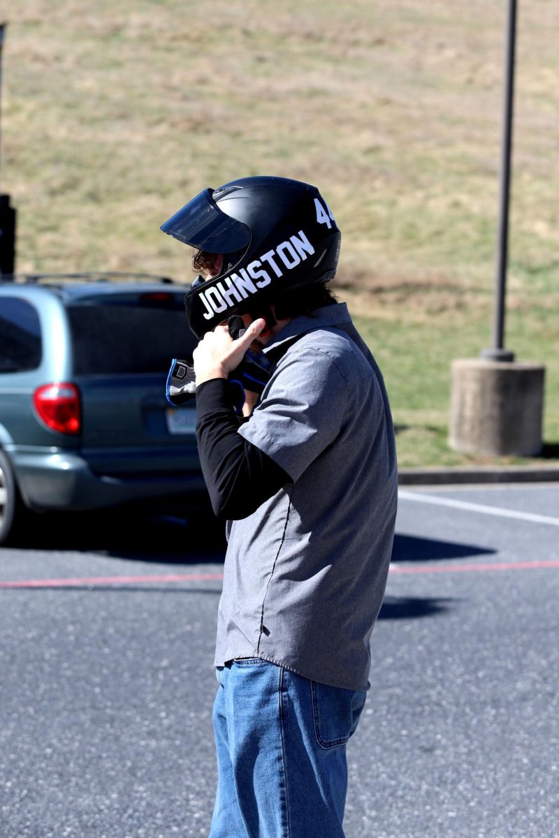 Senior Davis Bert puts on his helmet, getting ready to drive to drive.
