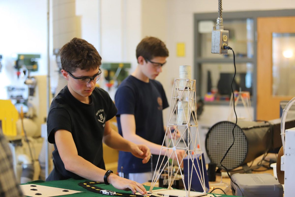 Sophomore Josiah Nafziger secures his tower to the table with tape.