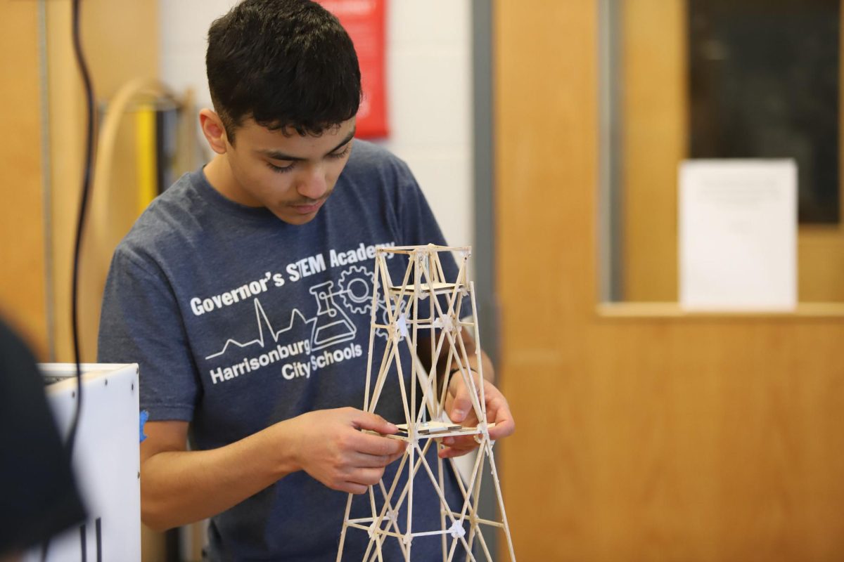 Eliel Cortina secures the weight plate to his team's tower.