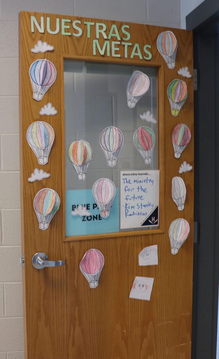 The next Spanish teacher at Harrisonburg High School is Sra. Romero. Her classroom entrance is adorned with artistic decor, making it colorful and inviting for students. The door is almost always open, allowing students to pass by easily.