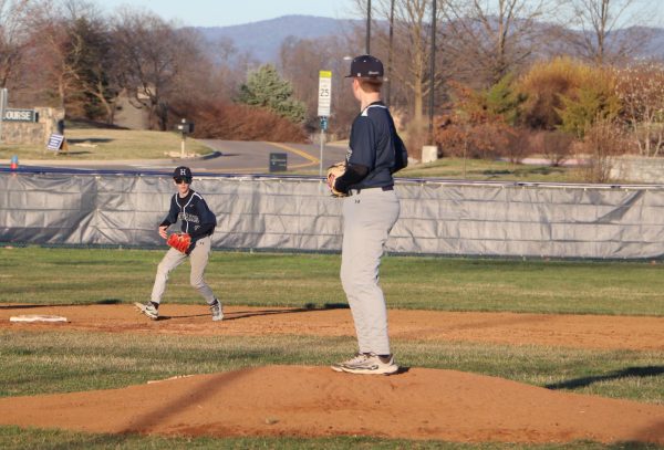 Eighth grader Andrew Noll looks at his teammate before pitching