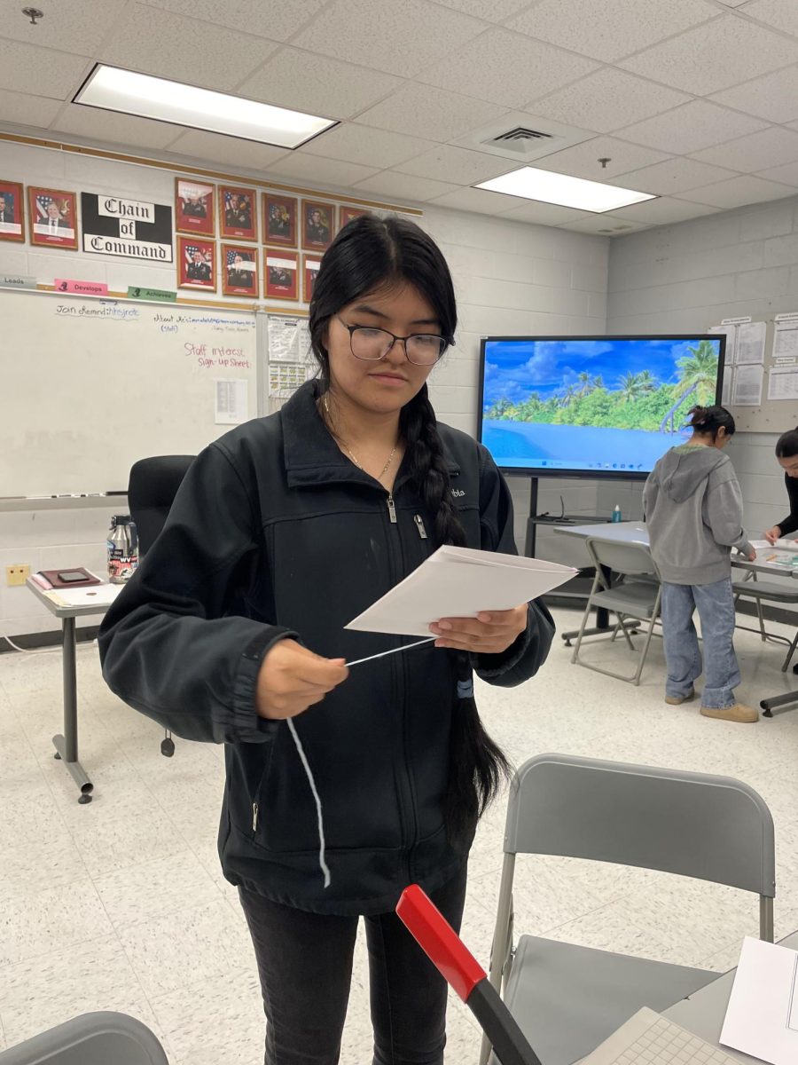Sophomore Elizabeth Santiago is working on tieying up the programs 