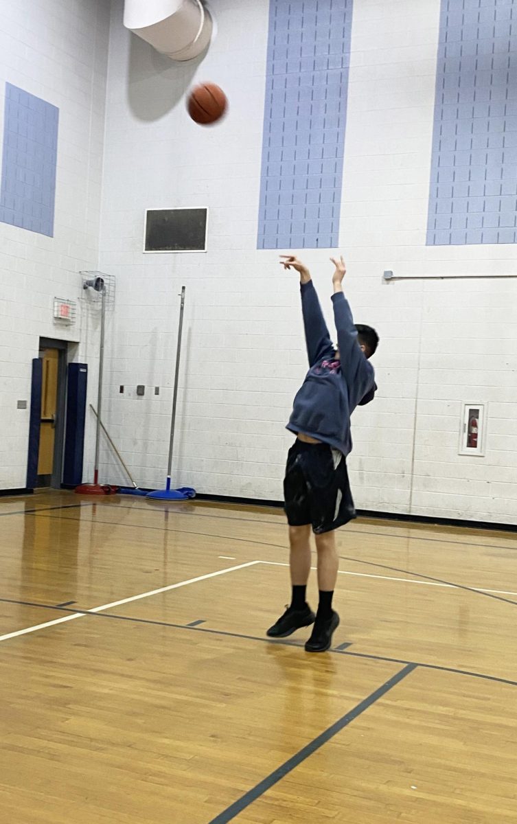 Freshman shoots the ball in the basketball unit.