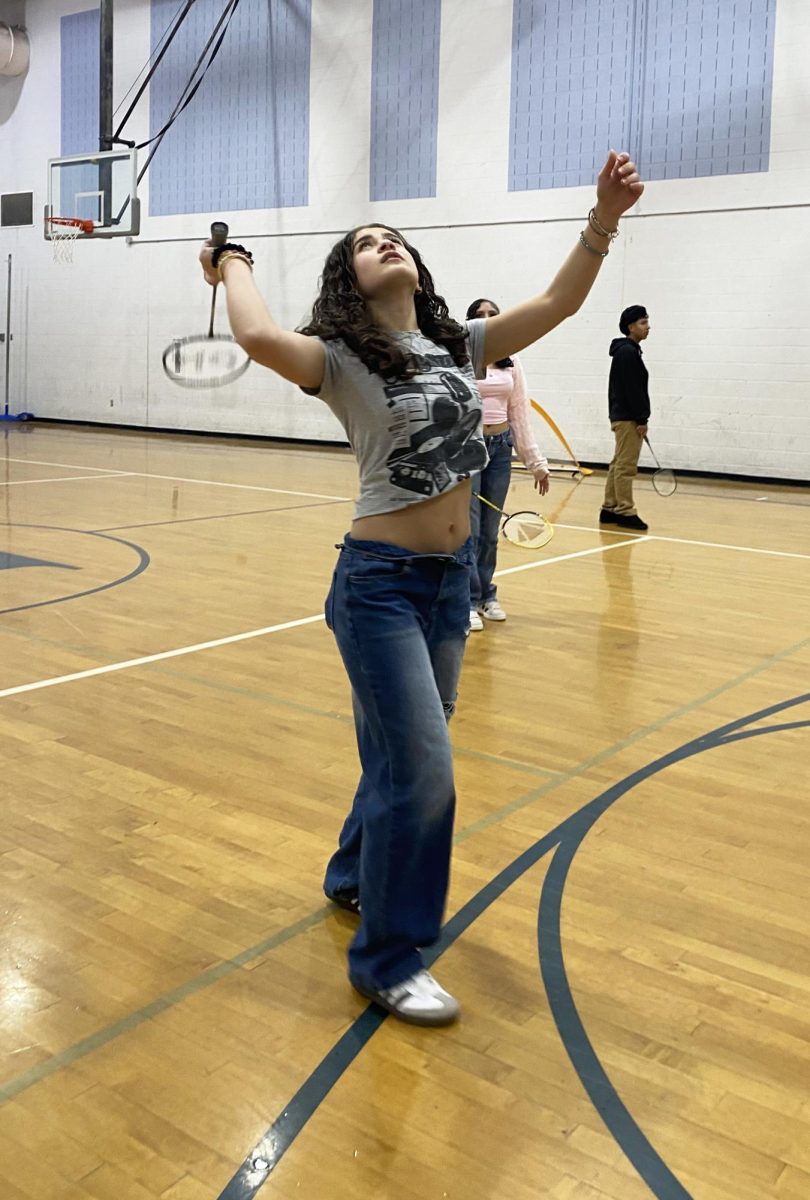 Freshman Yara Jalal serves in her game of badminton.