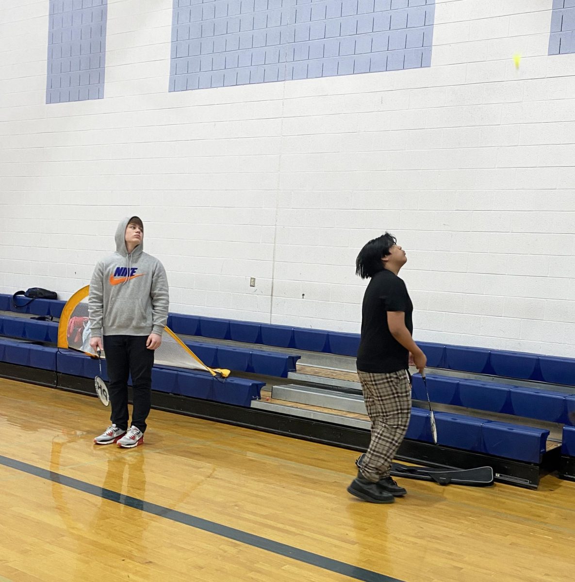 Two freshman play badminton together.