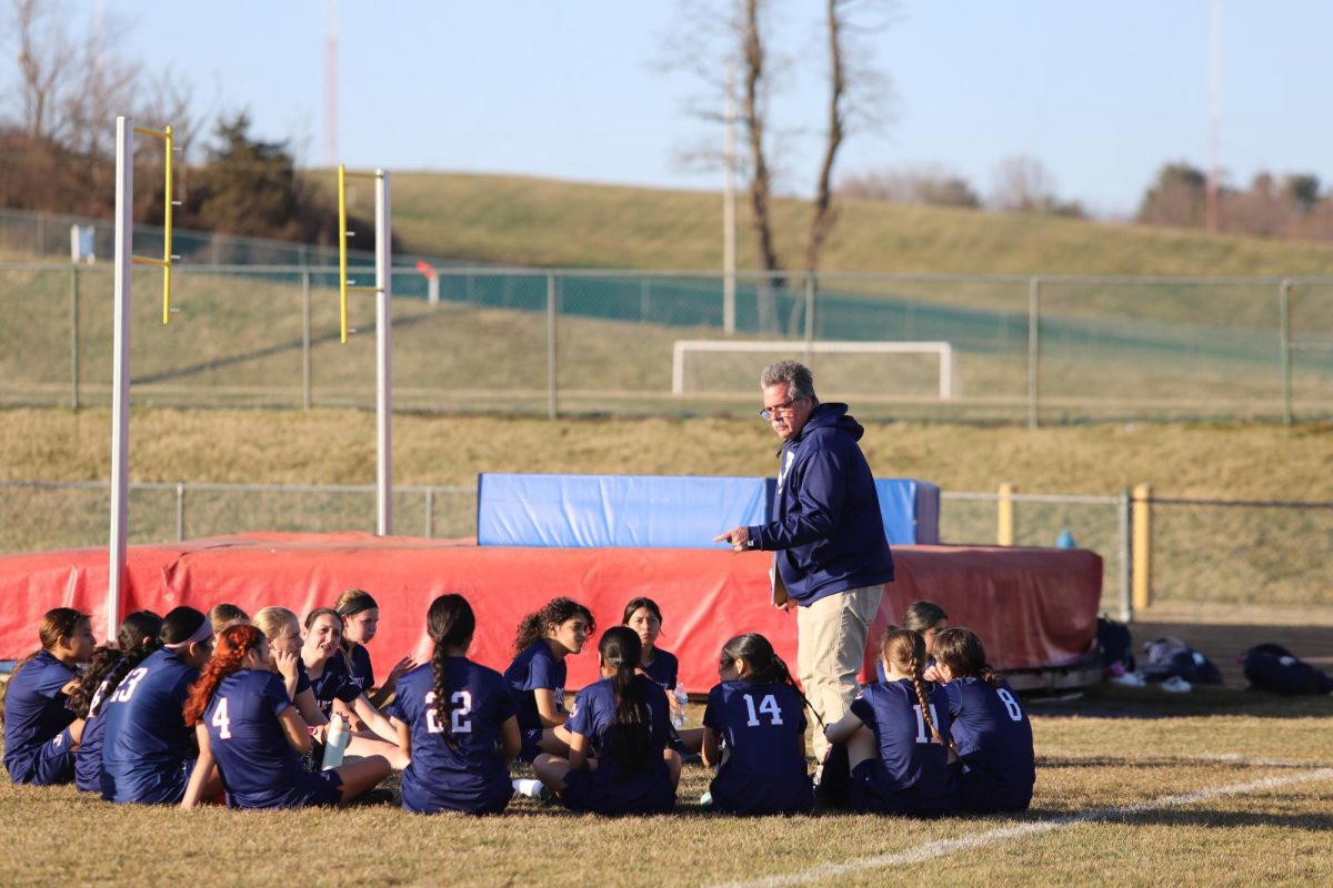 Soccer players have a team huddle. 