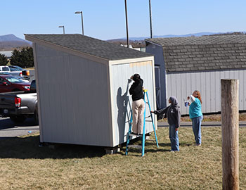 Sophomore Elsa Gebremicheal painting on the backside of Habitat for Humanity shed. "It's kind of satisfying," said Gebremicheal