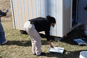 Sophomore Elsa Gebremichael rolling the paint roller to apply to the shed. "Well this is new," said Gebremichael.