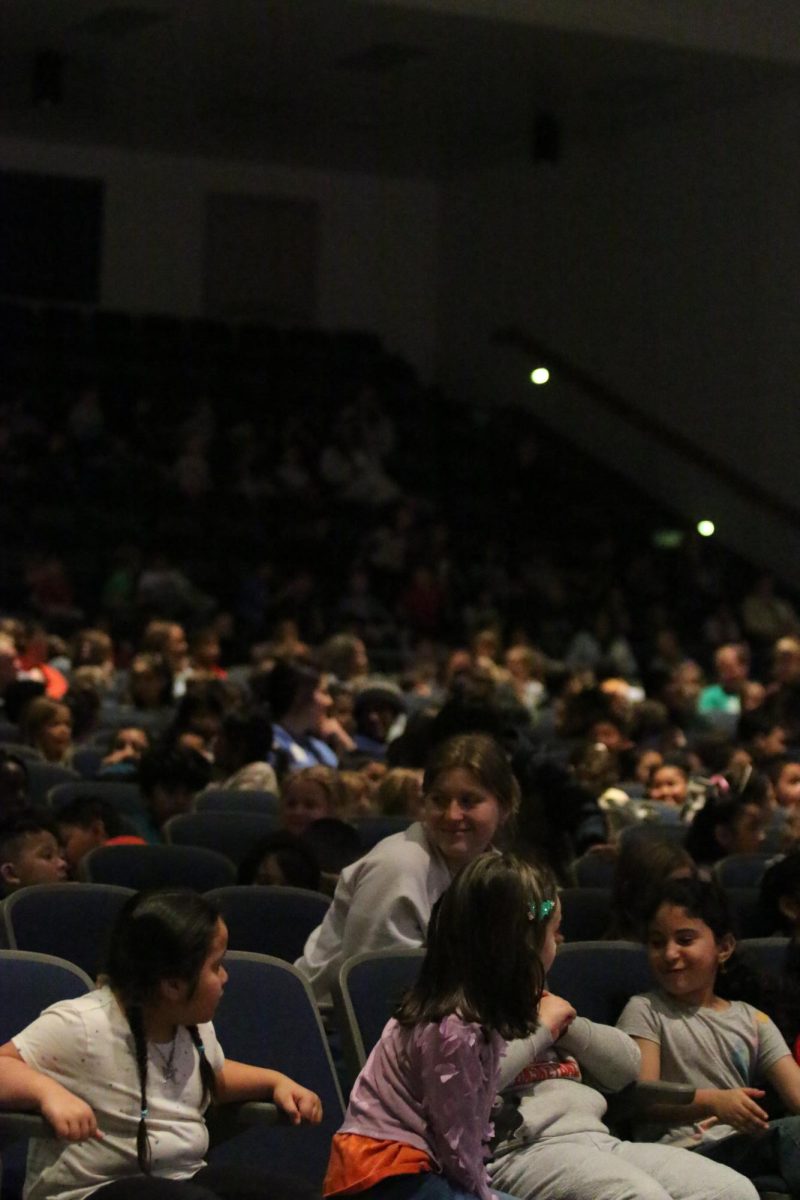 Elementary students watching the Tiny Tots performance."I love dressing up and running around for the children".-Davis Bert.