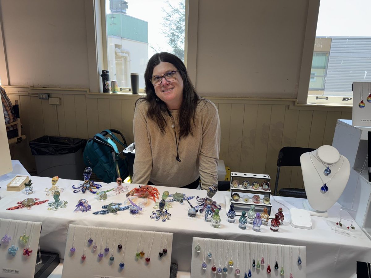 Tisbury Pringle-Ennis, owner of Tisbury Art Glass in Pike Place Market stands at her business stall.