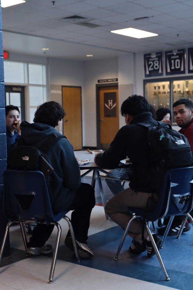 Students sitting at a table during lunch and hanging out.