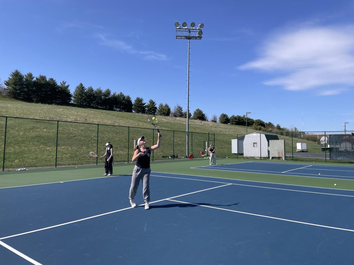 Junior Ann Snow  feeds balls to her short court partner. 
