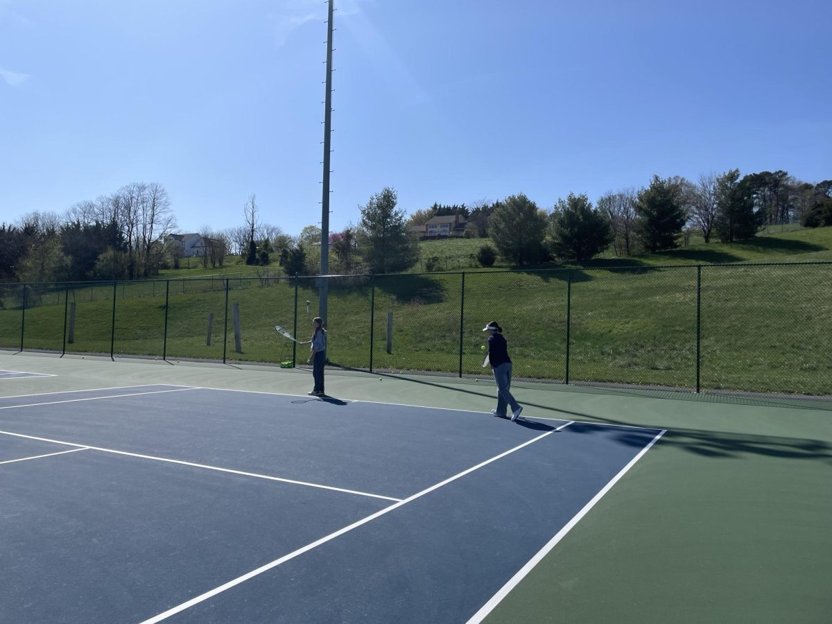 Senior Jill Pyle and Finnly Miller practice their backhand swings. 