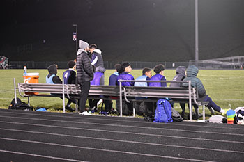 Bench players looking unto the soccer game.