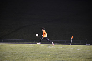 Senior Adolf R Rivas kicks the ball to the other side of the field.