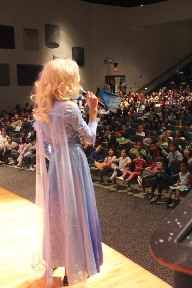A student dressed up as Elsa and singing