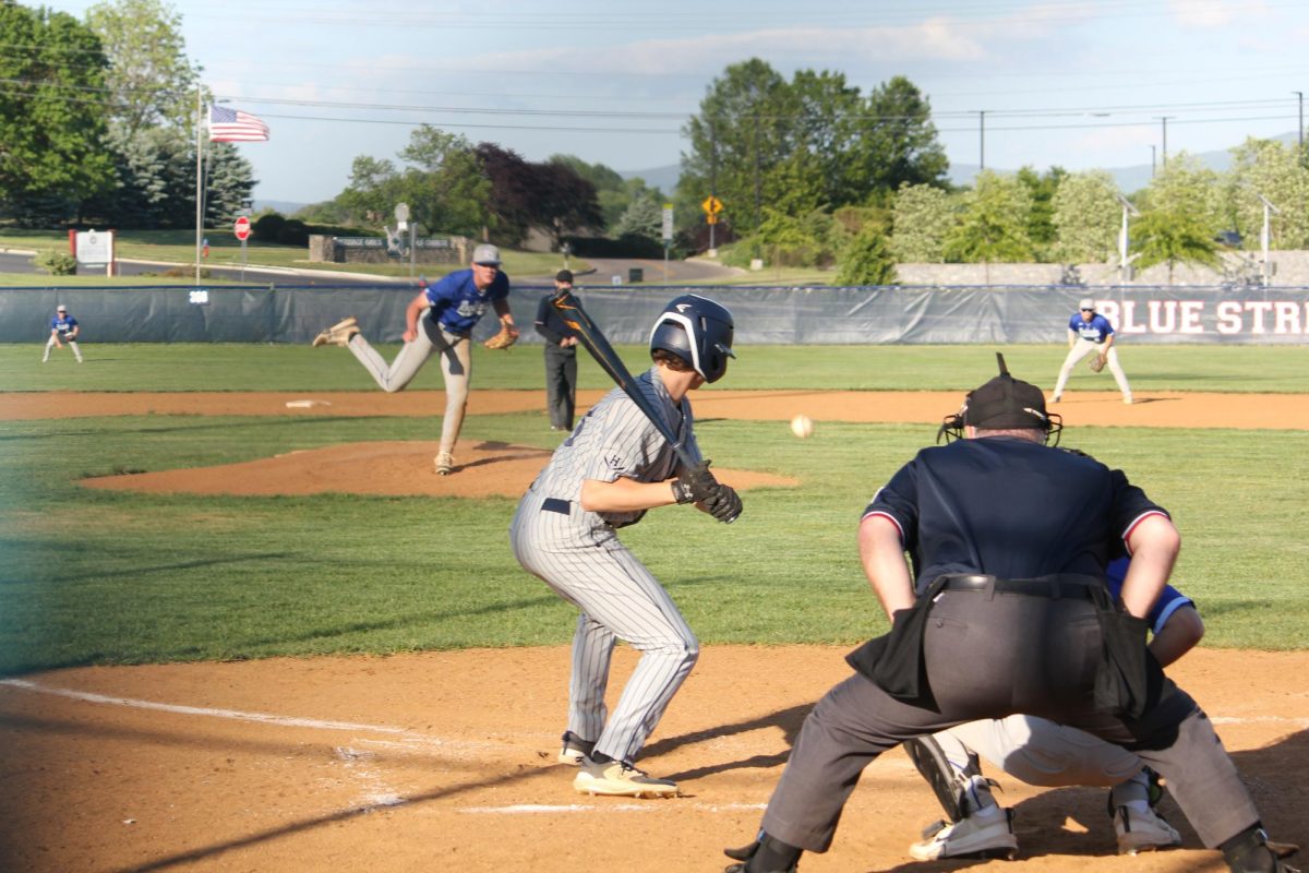 Stepping into the box with confidence, Junior, William Perrett locks eyes with the pitcher. Focused and ready, he prepares for the swing that sends the ball screaming into the outfield. Another strong offensive push from the Blue Streaks’ lineup.