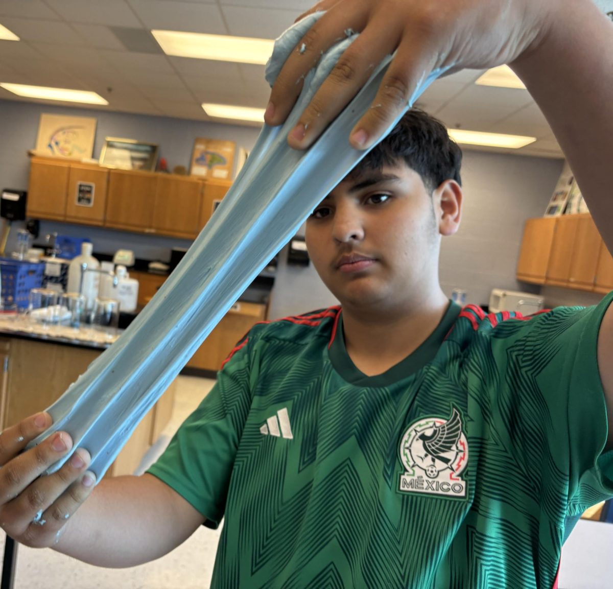 Sophomore Aaron Garcia stretching the slime he made.