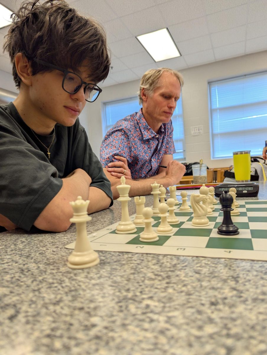 Dovis looks on as Mr. Kempe writes down the moves.