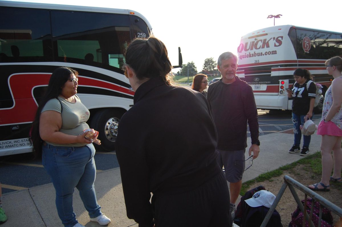 Mr. Healy joins in checking in students for the trip.