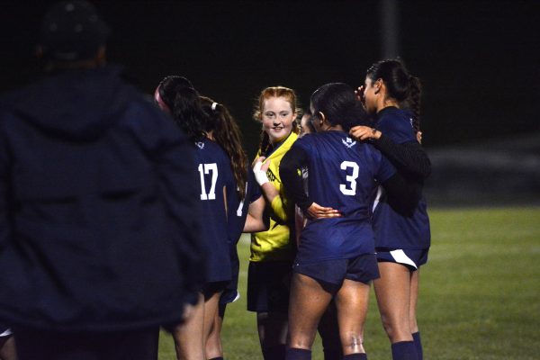 Hamilton and senior Leeanne Cara Irias listen to coach after game.
