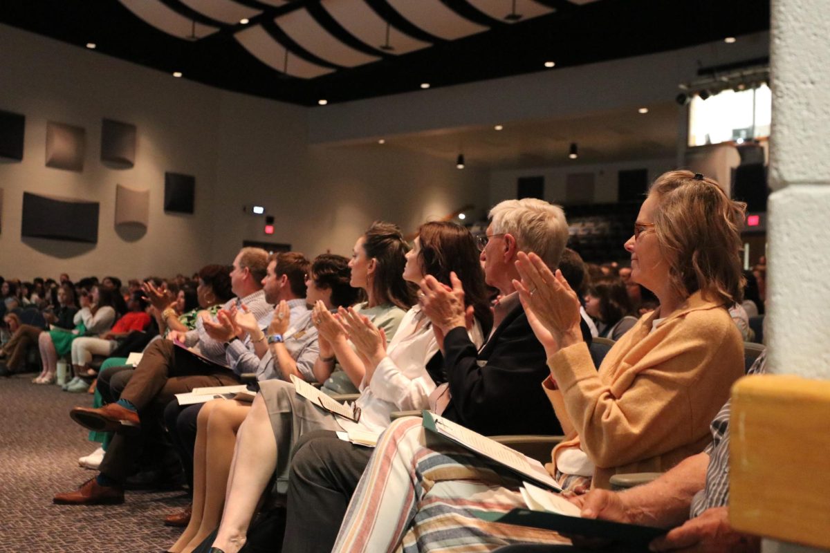 Award presenters clapping for seniors on stage at Senior Award Ceremony.