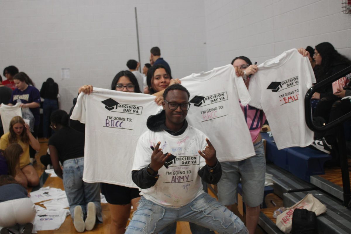 Senior Mia and Aaron and their friends are showing their signatures on their shirts.