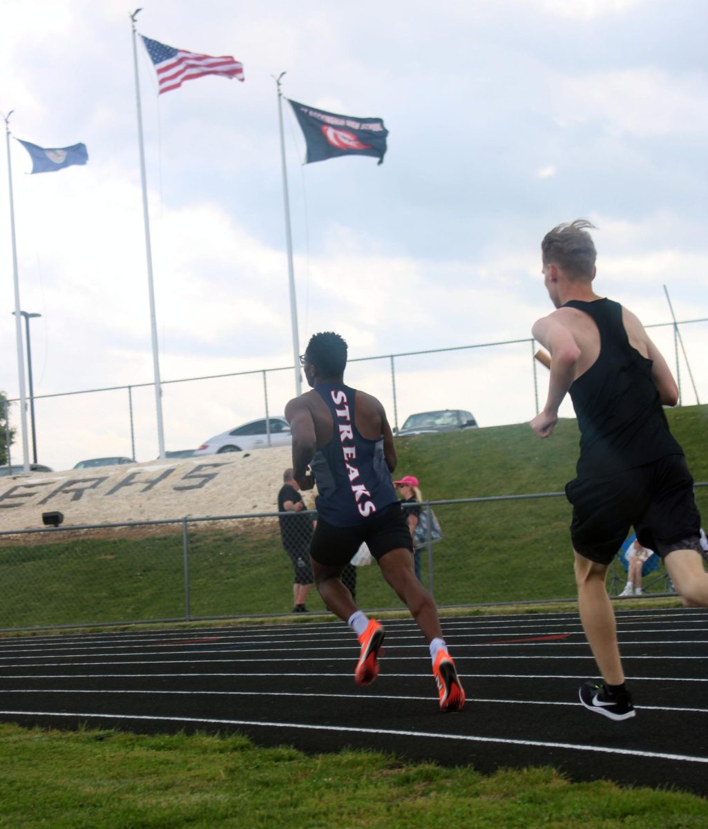 Ariel Huseni is running the 4x800. He has the team in first place, while TA is catching up shortly behind him. He works hard and breaks a sweat to try and win.