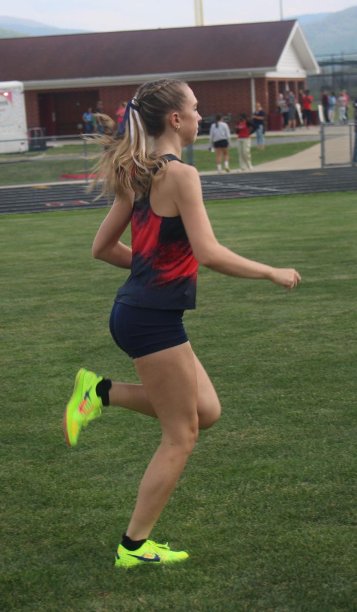 Abby Gibson is preparing for her next event. Shes is running the 4x800 and is warming up her body.