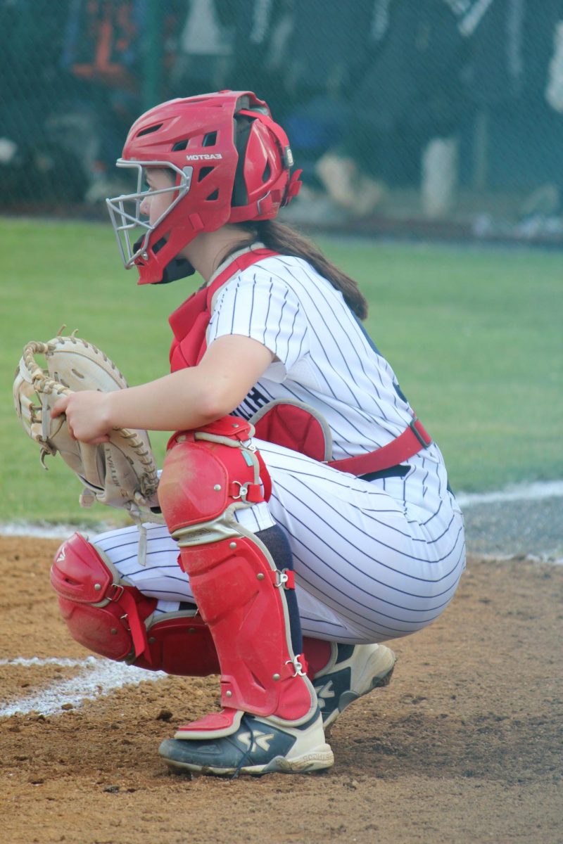 Not just here to fill a spot. Rachel Coffman, freshman varsity catcher, getting ready to catch the ball.