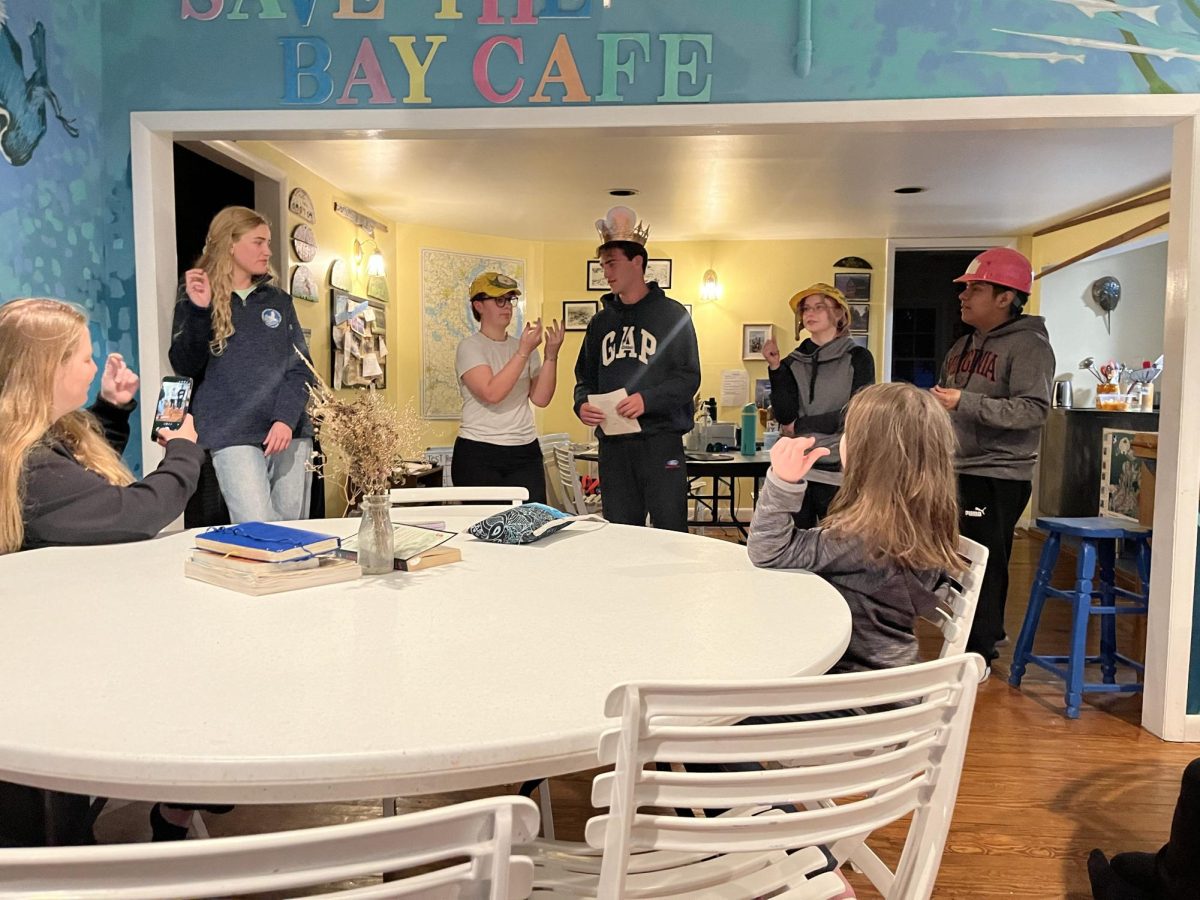 Before eating food, cook crew reads instructions to the rest of the students. 